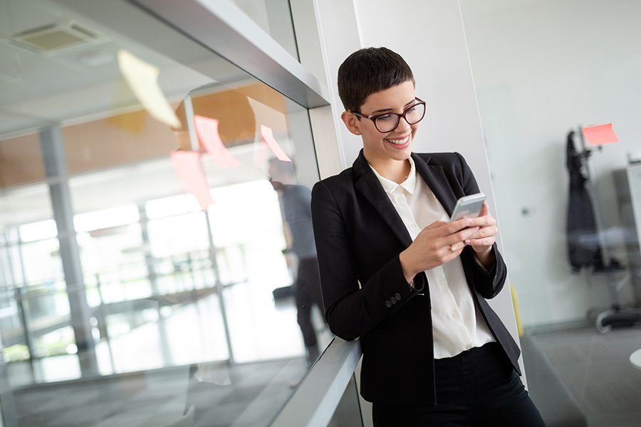 Client Center - Portrait of a Business Woman on a Her Phone Accessing Important Account Information in s Modern Office